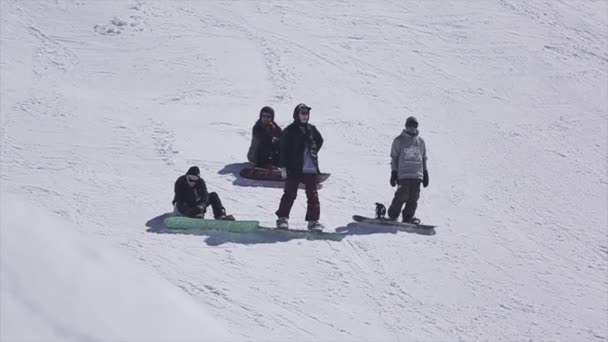 SOCHI, RUSIA - 2 DE ABRIL DE 2016: Snowboarders on slope on ski resort. Día soleado. Montañas nevadas. Cabalgando . — Vídeo de stock