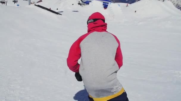 Sochi, Ryssland - April 2, 2016: Snowboardåkare bild på järnväg. Solig dag. Skidorten. Snötäckta berg. Extrem sport — Stockvideo