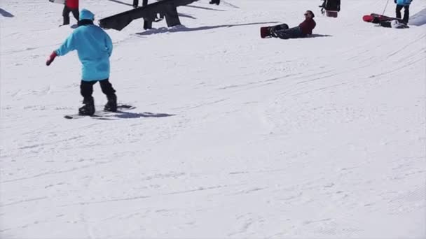 Soczi, Rosja - 2 kwietnia 2016: Snowboardzista slajdów na szynie na ośrodek narciarski. Słoneczny dzień. Snowy góry. Akrobacje — Wideo stockowe