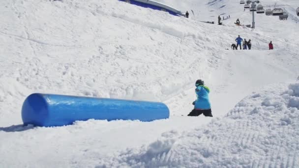 SOCHI, RUSIA - 2 DE ABRIL DE 2016: Deslizamiento hacia atrás del esquiador, saltar en pateador. Día soleado. Estación de esquí. Montañas nevadas — Vídeo de stock