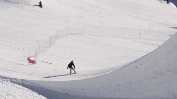 SOCHI, RÚSSIA - 2 de abril de 2016: Passeio de snowboard no trampolim. Vira o ar. Ensolarado. Estância de esqui. Extremo — Vídeo de Stock