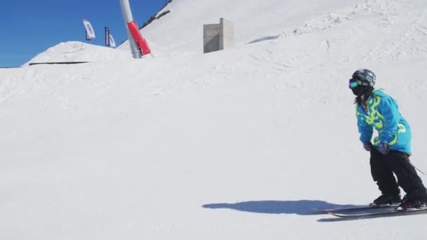 SOCHI, RUSIA - 2 DE ABRIL DE 2016: Deslizamiento de esquiador en pendiente, saltar sobre raíl. Día soleado. Estación de esquí. Montañas. Extremo. . — Vídeo de stock