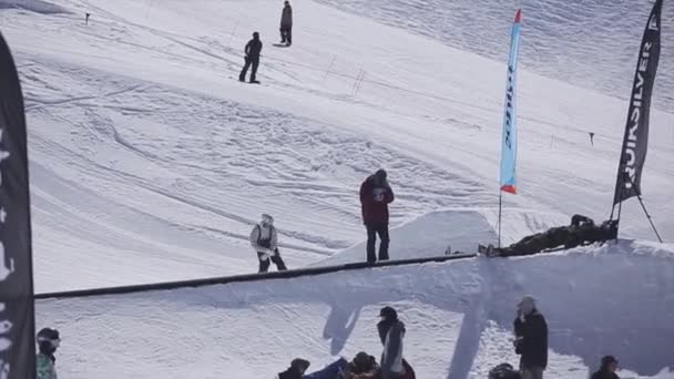 Sochi, Rusland - 2 April 2016: Snowboarder sprong van de Springplank in skigebied. Zonnige dag. Bergen. Publiek — Stockvideo