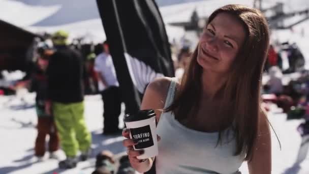 Сочі, Росія - 2 квітня 2016: Дівчина з посмішкою кави в камеру у Енкамп серед інших людей. Гірськолижний курорт. — стокове відео