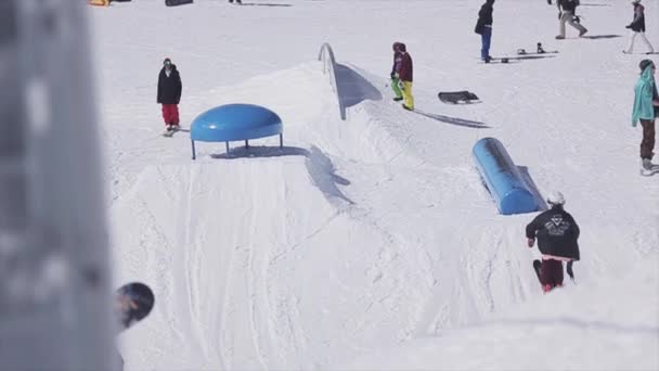 SOCHI, RUSIA - 2 DE ABRIL DE 2016: Deslizamiento de esquiador en pateador. Estación de esquí. Trucos extremos. Deporte activo. Gente. Soleado. — Vídeo de stock