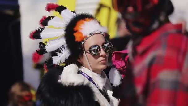 SOCHI, RUSIA - 2 DE ABRIL DE 2016: Chica en sombrero con plumas y gafas de sol bailan en el campamento. Estación de esquí. Gente . — Vídeos de Stock