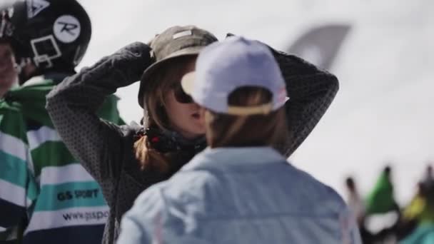 SOCHI, RUSIA - 2 DE ABRIL DE 2016: Una joven con gafas de sol habla con un hombre en el campamento. Estación de esquí. Snowboarders — Vídeos de Stock