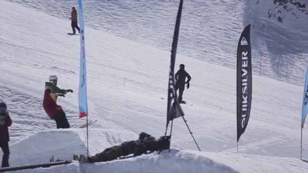 SOCHI, RUSIA - 2 DE ABRIL DE 2016: Salto de esquiador desde trampolín en la estación de esquí. Día soleado. Montañas nevadas. Extremo. — Vídeos de Stock