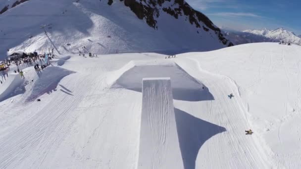 SOCHI, RÚSSIA - 2 de abril de 2016: Quadrocopter atirar salto snowboarder de trampolim. Montanha nevada. Pessoas — Vídeo de Stock