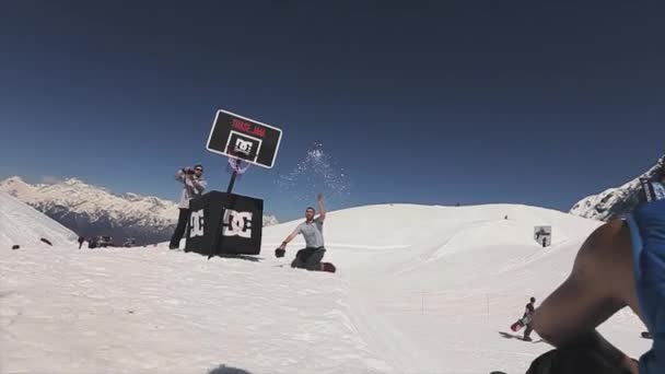 SOCHI, RUSIA - 1 DE ABRIL DE 2016: Snowboarder hacer salto mortal en el trampolín tratar de lanzar la pelota en la cesta. Gente . — Vídeos de Stock