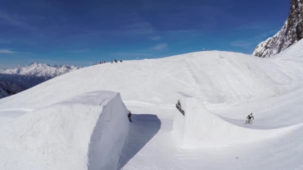 SOCHI, RUSSIA - APRIL 2, 2016: Quadrocopter shoot snowboarder jump from springboard. Snowy mountain. Ski resort — Stock Video