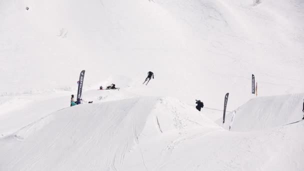 SOCHI, RUSSIE - 1er AVRIL 2016 : Skieur faire un saut en hauteur à partir du tremplin, monter sur la pente. Station de ski. Les gens — Video