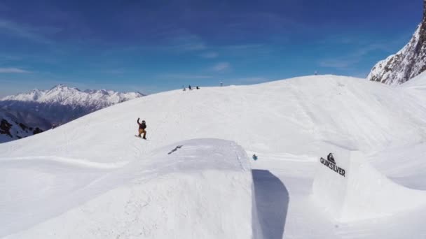 SOCHI, RÚSSIA - 2 de abril de 2016: Quadrocopter atirar snowboarder salto de trampolim, fazer acrobacias. Paisagem — Vídeo de Stock