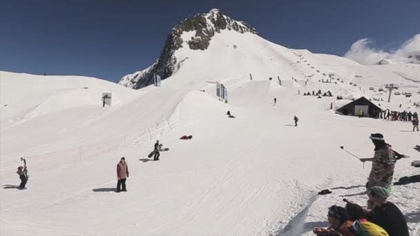 Sochi, Rusland - 1 April 2016: Snowboarder maken sprong op de Springplank gooien bal in de mand. Mensen. Snelheid. — Stockvideo