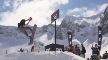 Soçi, Rusya - 1 Nisan 2016: Snowboarder sıçrama tahtası atmak top basketbol sepet içinde binmek. Seyirci. Spor