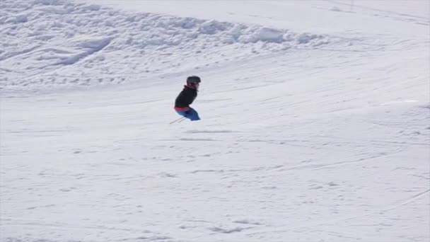Sotschi, Russland - 2. April 2016: Skifahrer mit Helm springt vom Sprungbrett auf Skigebiet. sonniger Tag. Schneebedeckte Berge. — Stockvideo