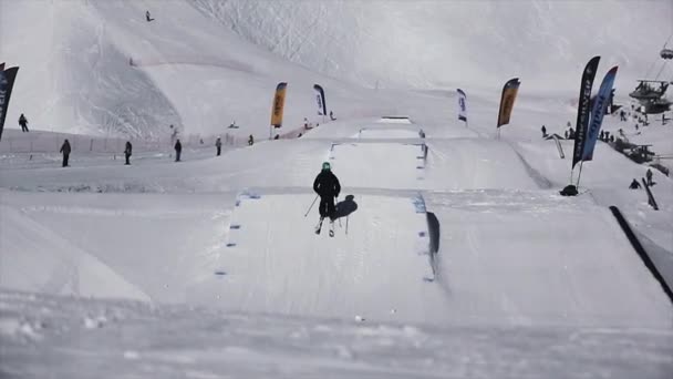 SOCHI, RUSSIE - 1er AVRIL 2016 : Le skieur fait un saut extrême depuis le tremplin, pieds flexibles dans l'air. Montagnes enneigées. Station de ski. Journée ensoleillée — Video