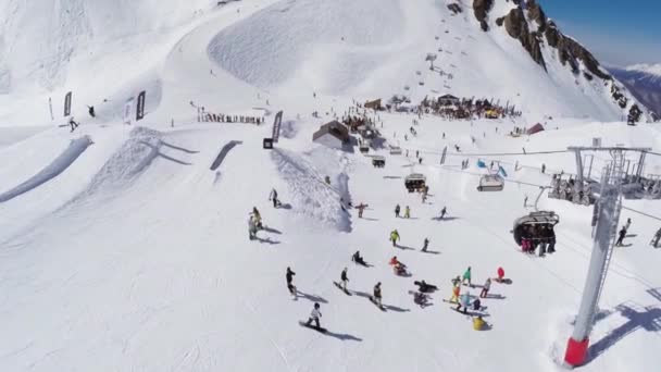 Sochi, Ryssland - April 2, 2016: Quadrocopter flyga över snowboardåkare, skidåkare på ski resort. Skidliftar. Encamp — Stockvideo