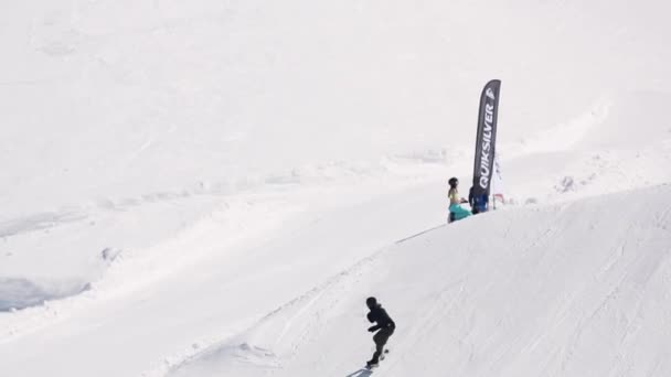 СОЧИ, РОССИЯ - 1 апреля 2016 года: Прыжок сноубордиста с трамплина в высоту, разворот в воздухе. Лыжный курорт. Скорость — стоковое видео