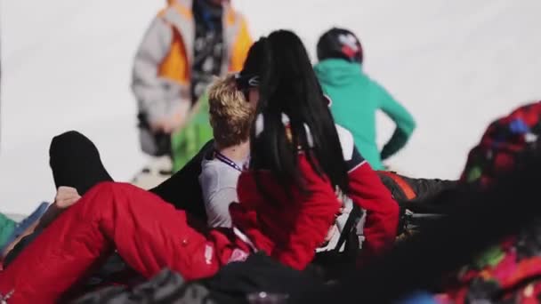 СОЧИ, РОССИЯ - 2 апреля 2016 года: Девушка в солнечных очках отдыхает в лагере среди других людей. Лыжный курорт. Солнечный день — стоковое видео