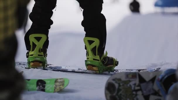 SOCHI, RUSSIA - APRIL 1, 2016: Snowboarders stay on slope prepare for riding. Ski resort. Mountains. Extreme. — Stock Video