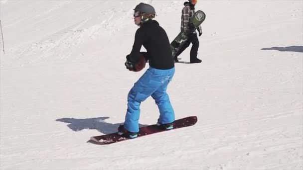 SOCHI, RUSIA - 1 DE ABRIL DE 2016: Paseo de snowboarder en una pelota de lanzamiento de trampolín en una canasta de baloncesto. Gente. Resort . — Vídeos de Stock