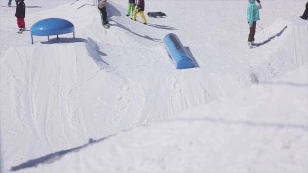 SOCHI, RUSIA - 2 DE ABRIL DE 2016: Snowboarder slide on blue kicker. Estación de esquí. Extremadamente. Deporte activo. Gente . — Vídeo de stock