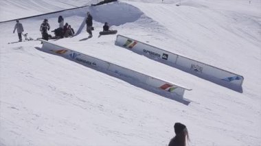 Sochi, Rusya Federasyonu - 2 Nisan 2016: Kayakçı tek ayak üstünde slayt Ray üzerinde olun. Kayak Merkezi. Güneşli bir gün. Dağlar. İnsanlar.