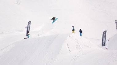 Sochi, Rusya Federasyonu - 1 Nisan 2016: Snowboarder yüksek atlama sıçrama tahtası üzerinden yapmak, yamaçta binmek. Kayak Merkezi. İnsanlar