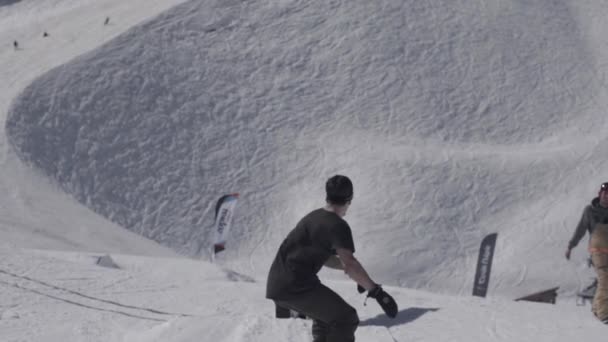 Snowboarder glisser sur piste de fer. Paysage de montagnes enneigées. Des pentes. Les gens. Journée ensoleillée. Remontées mécaniques — Video