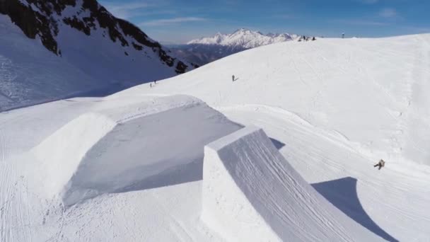 Sochi, Oroszország - április 2-án, 2016: Quadrocopter lő snowboardos hogy nagy ugrás az ugródeszka. Hegyek. Napos — Stock videók