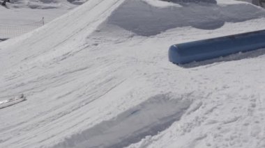 Siker sıçrama tahtası üzerinde aşırı binmek olun. Kar dağlar. Güneşli bir gün. İnsanlar. Eğim. Stunts. Kayak Merkezi