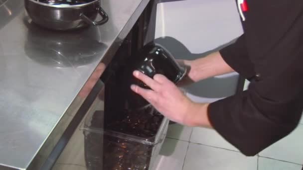 Cook ρίχνει καθαρισμένα μύδια από το τηγάνι σε διάφανο δοχείο στο ψυγείο. Κουζίνα εστιατορίου — Αρχείο Βίντεο