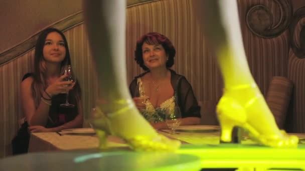 Dancing feet on table, girl and woman at table and look on background. Burlesque — Stock Video