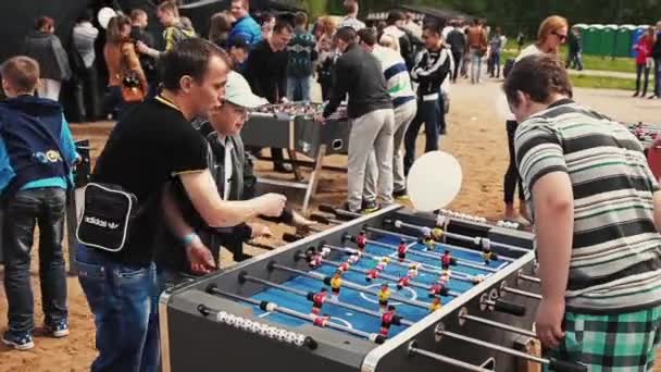 SAINT PETERSBURG, RÚSSIA - 6 de setembro de 2014: Dois adolescentes e homens adultos jogam futebol americano de mesa. Festival de verão — Vídeo de Stock