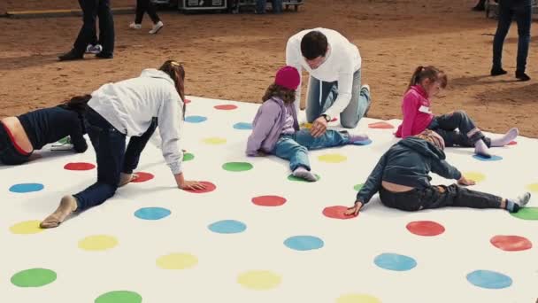 Petrohrad, Rusko - září 6, 2014: Děti obrovské twister hru hrát na ulici. Dospělí jim pomoci. Letní festival. — Stock video