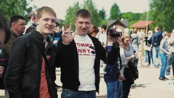 상트페테르부르크, 러시아-2014 년 9 월 6 일: 두 젊은 남자 여름 축제에는 카메라에 포즈. 화창한 날입니다. 손가락 제스처 — 비디오