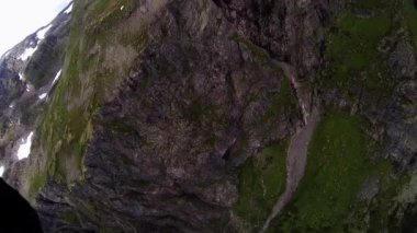 Skydiver kar ve yeşilliklerle kaplı Dağları üzerinde paraşütle atlama. Kanyon