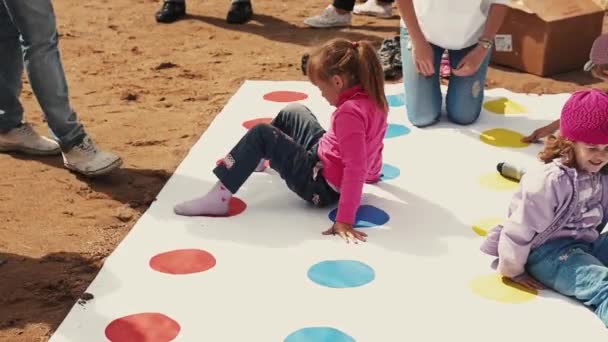 SAINT PETERSBURG, RUSSIA - SEPTEMBER 6, 2014: Children play huge popular twister game on street. Summer festival. Sunny day — Stock Video