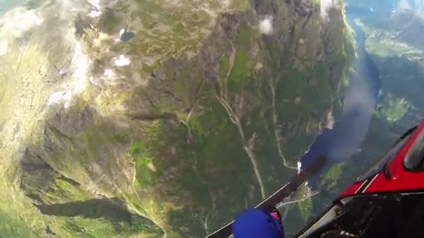 Skydiver saltar de avião acima das montanhas cobertas por vegetação. Desporto extremo . — Vídeo de Stock