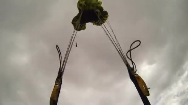 Скідайвер відкриває парашут над горами, вкритими зеленню. Екстремальні види спорту . — стокове відео