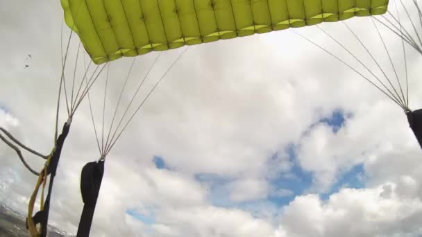 Skydiver open parachutespringen boven bergen bedekt door groen. Extreme sporten. — Stockvideo