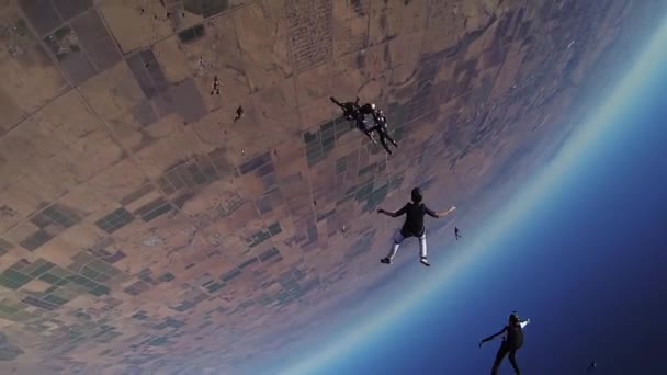 Groep parachutisten maken vorming in blauwe hemel. Open parachute boven arizona. — Stockvideo