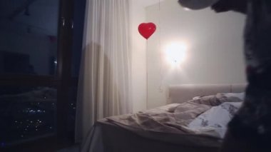 Genç kadın pijama yatak odası çay ile panoramik penceresinde gelmek. Hava balonları. Karanlık gece