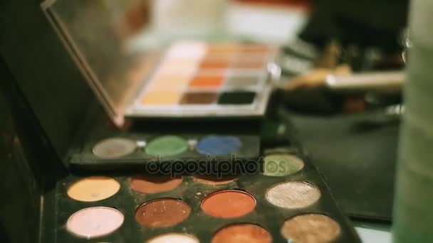 Make up designer put brush in colorful bright eye shadows. Cosmetics. Beauty. Women. Mirror — Stock Video