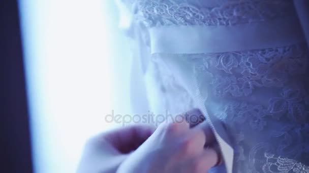 Mulher amarrar fitas de volta lado do vestido de noiva rendada para a noiva. Dia da celebração. Casamento. Tons calmos . — Vídeo de Stock