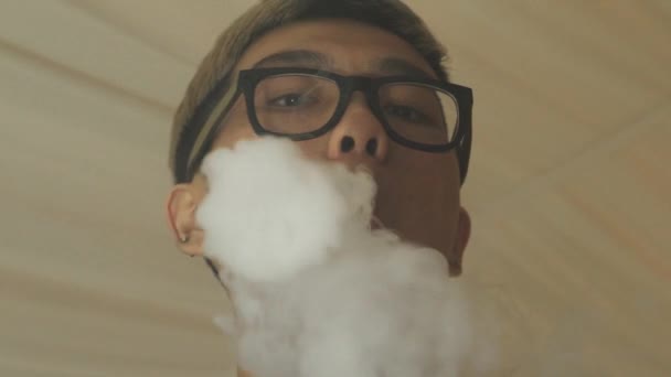 Asiatiska boy i glas andas ut ånga från elektronisk cigarett. Vaper. Subkultur — Stockvideo