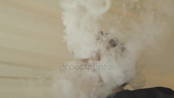 メガネのアジアの十代の少年には、電子タバコからの蒸気が息を吐きます。気。喫煙者. — ストック動画