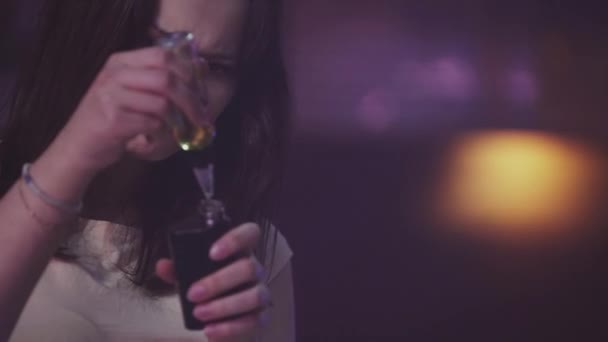 Kız gece kulübünde elektronik sigara içine sıvı dökün. Vaper. Sahne ışıkları. — Stok video