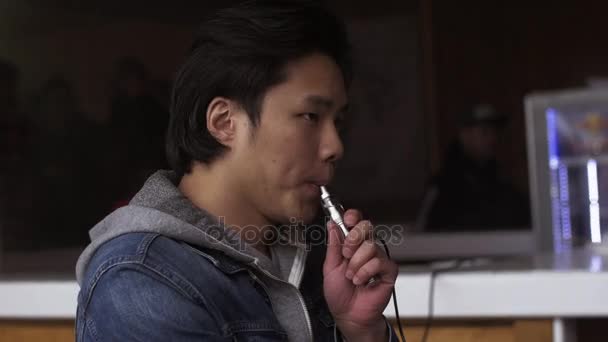 Aziatisch mens uitademing stoom van elektronische sigaret op stand. Vaper. Roker — Stockvideo